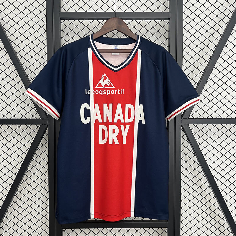 Mens PSG Retro Home Jersey 1974/75 Mens PSG Retro Home Jersey 1974/75 on hanger showing navy body with central red Hechter stripe and Canada Dry sponsor