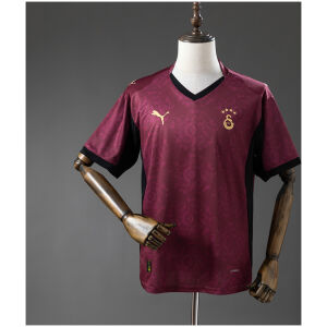 Mens Galatasaray Third Jersey 2025/26 on rack showing deep maroon damask body with black V-neck insert and gold crest