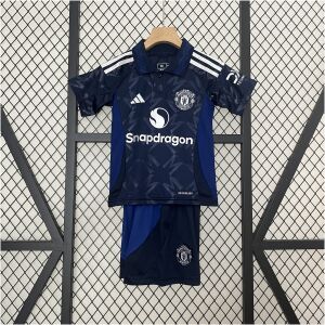 Kids Manchester United Away Kit 2024/25 on hanger showing navy monogram shirt with royal blue polo collar and shorts