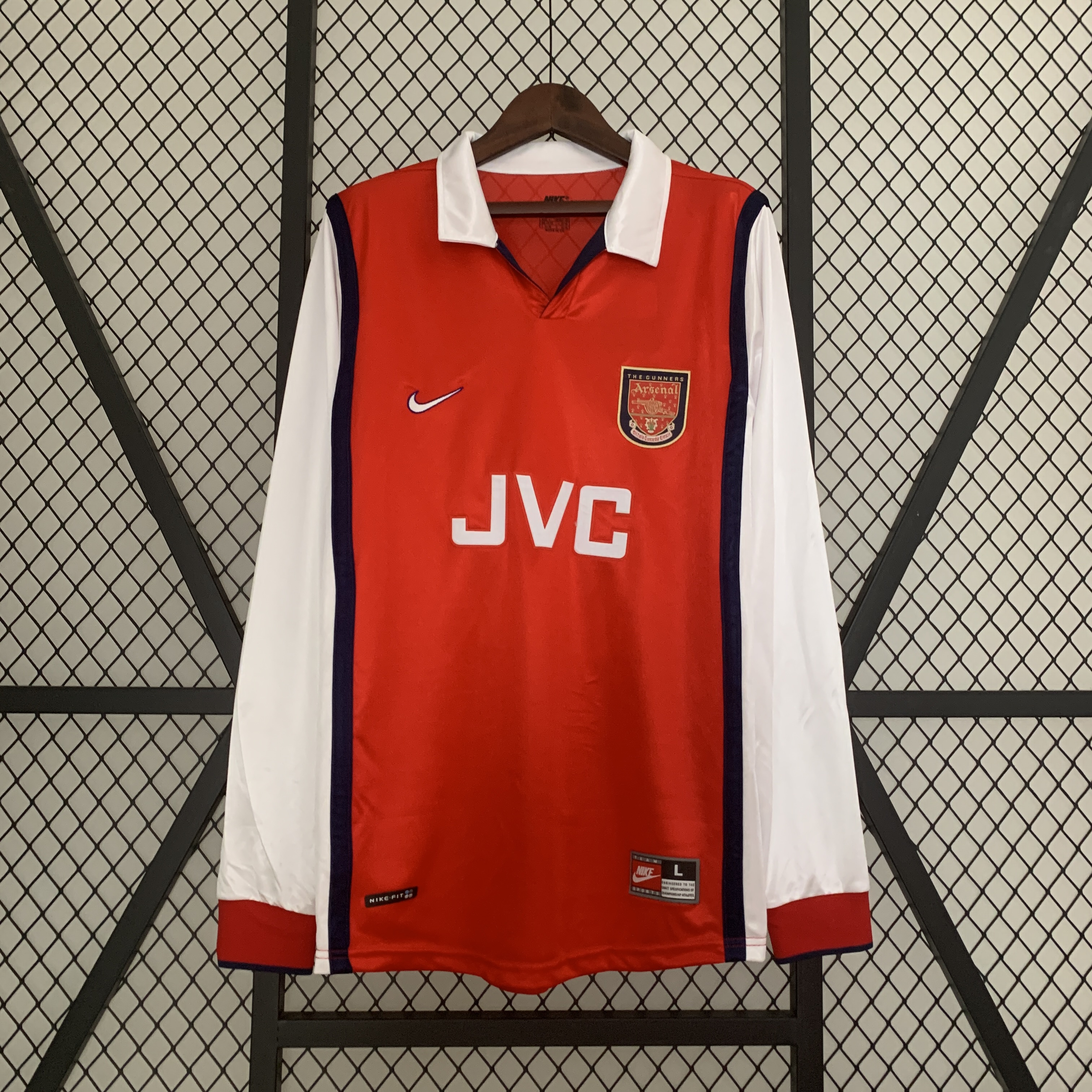Mens Arsenal Retro Long Sleeve Home Jersey 1998/99 Mens Arsenal Retro Long Sleeve Home Jersey 1998/99 on hanger showing red body with long white sleeves and JVC sponsor