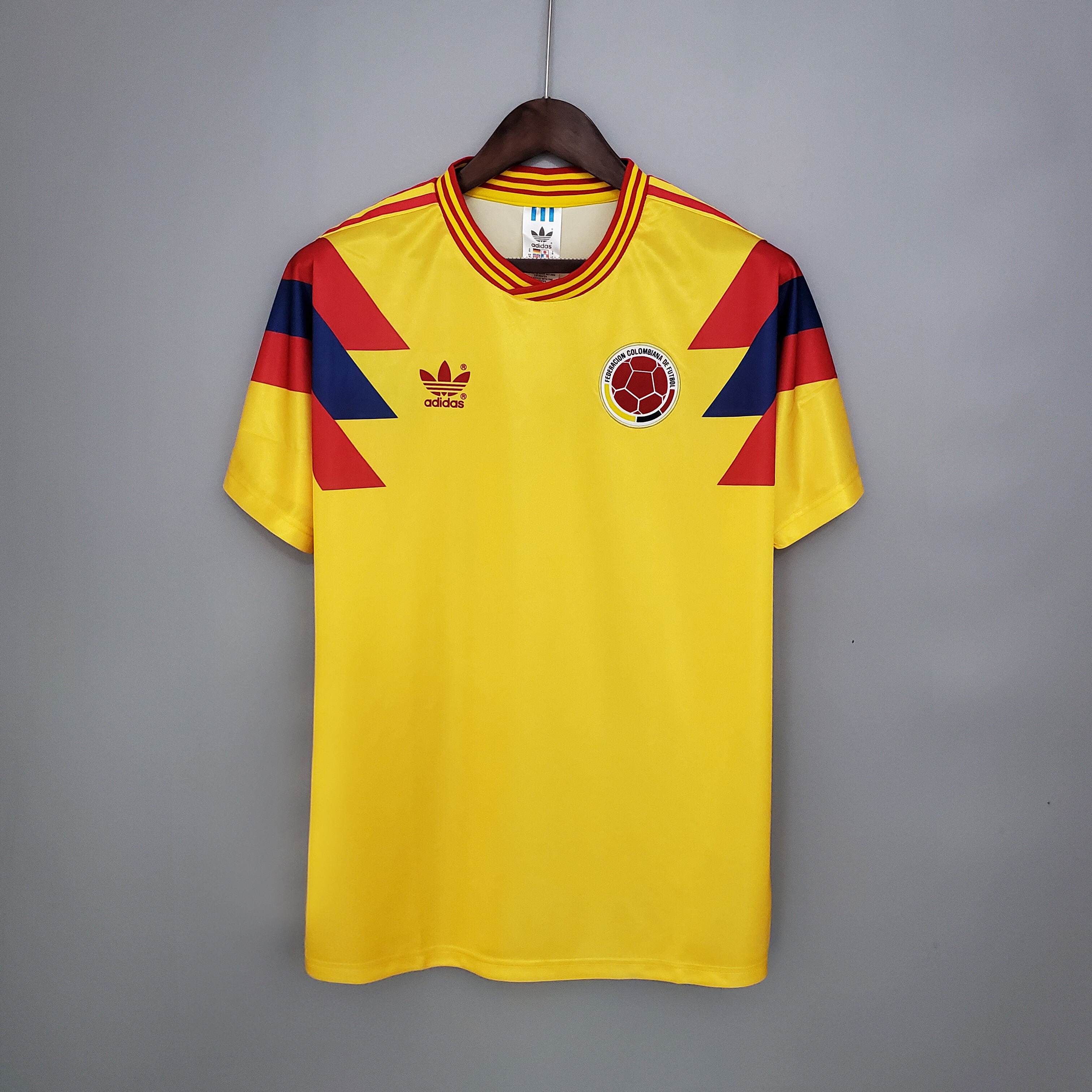 Mens Colombia yellow Retro Home Jersey 1990 Mens Colombia yellow Retro Home Jersey 1990 front view on hanger showing yellow body and geometric shoulder panels