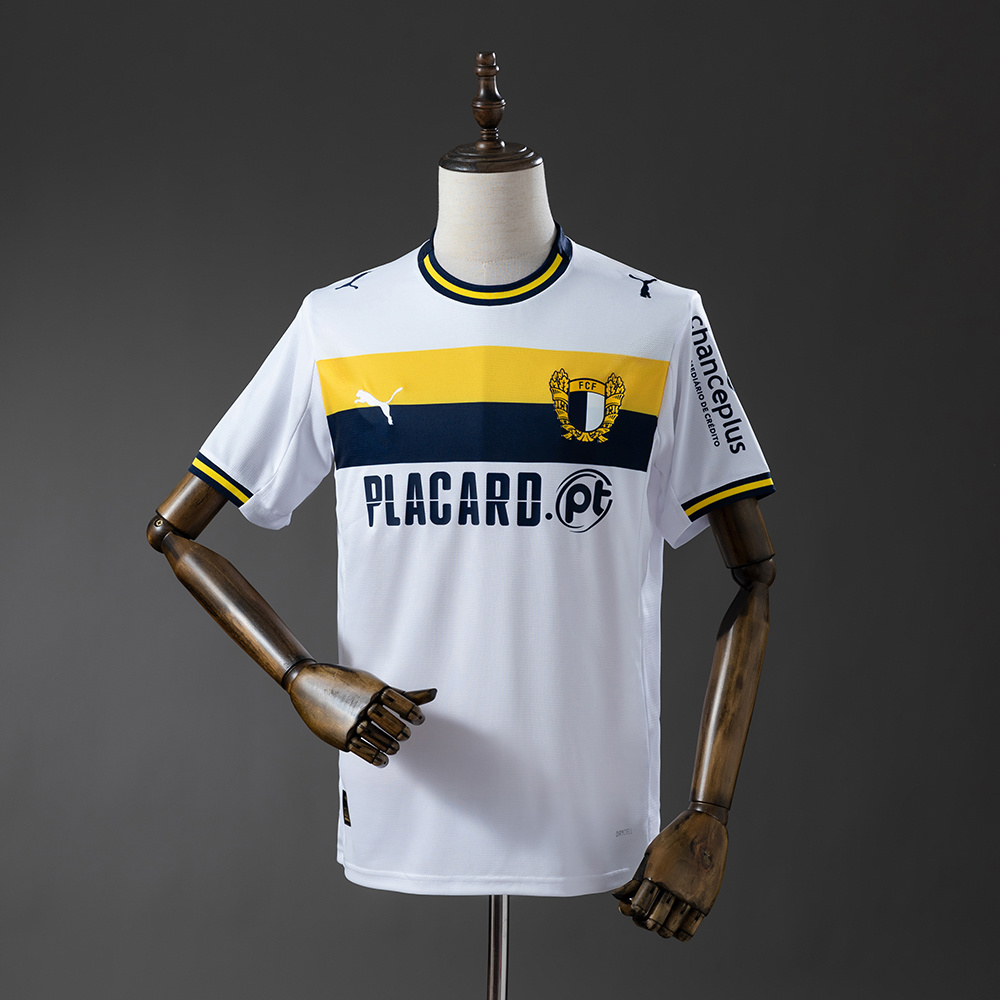 Mens Famalicao Home Jersey 2025/26 Mens Famalicao Home Jersey 2025/26 on mannequin showing white body with yellow and navy chest band and crest