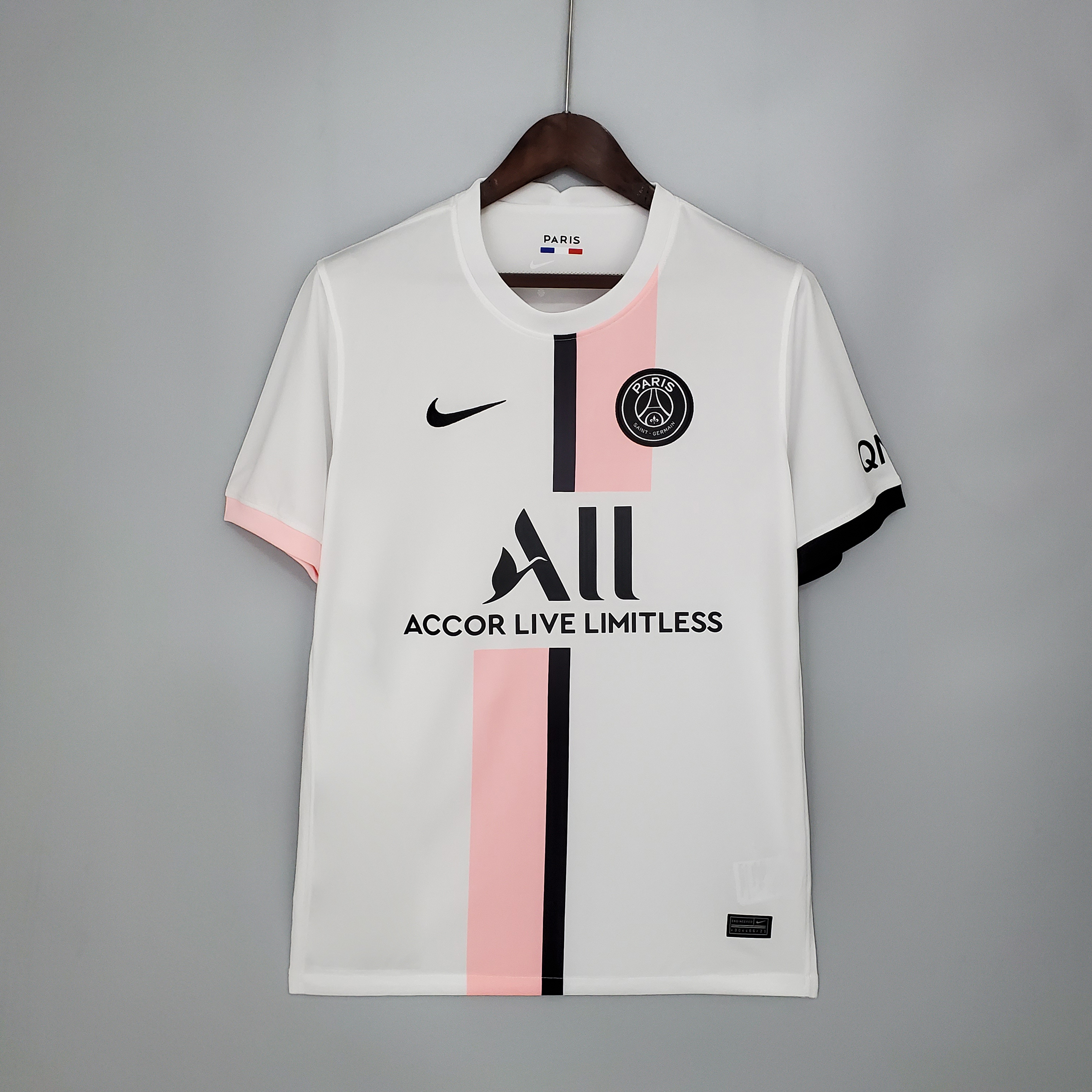 Mens PSG Away Jersey 2021/22 Mens PSG Away Jersey 2021/22 on hanger showing white body and asymmetric pink and black center stripe