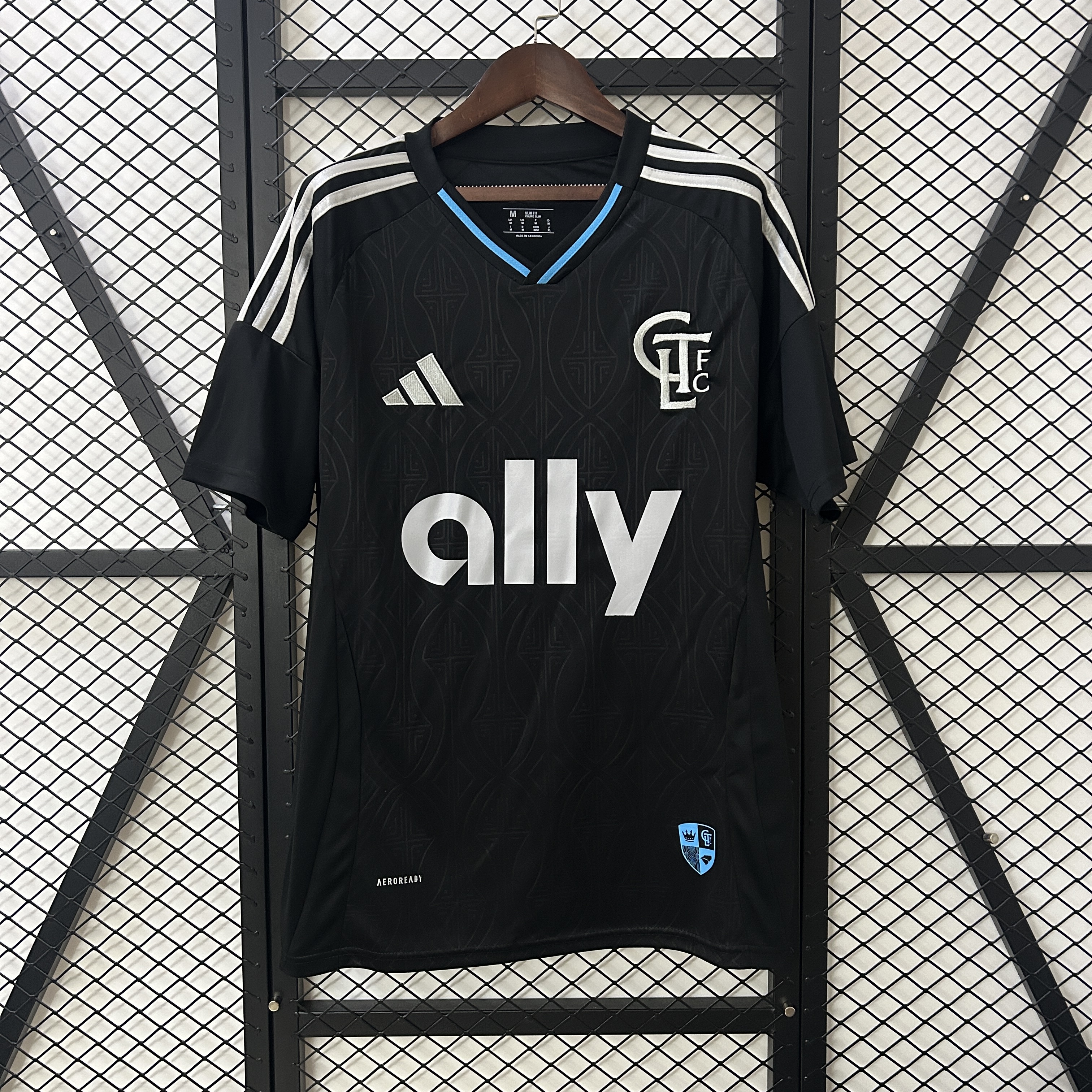 Mens Charlotte FC Away Jersey 2025/26 Mens Charlotte FC Away Jersey 2025/26 on hanger displaying black geometric pattern with silver CLTFC crest and ally logo
