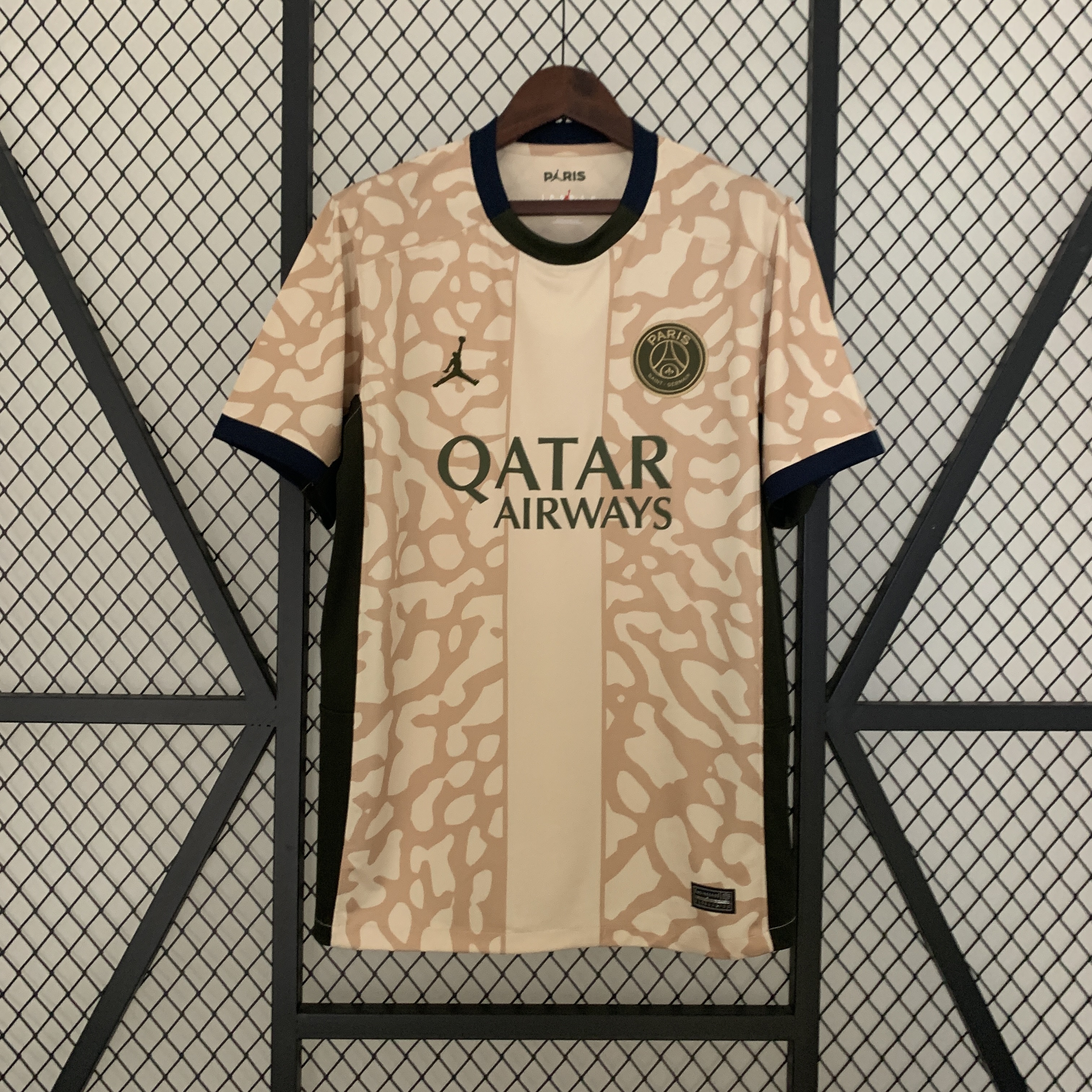 Mens PSG Fourth Jersey 2023/24 Mens PSG Fourth Jersey 2023/24 on hanger showing sand elephant print body with olive logos and navy collar