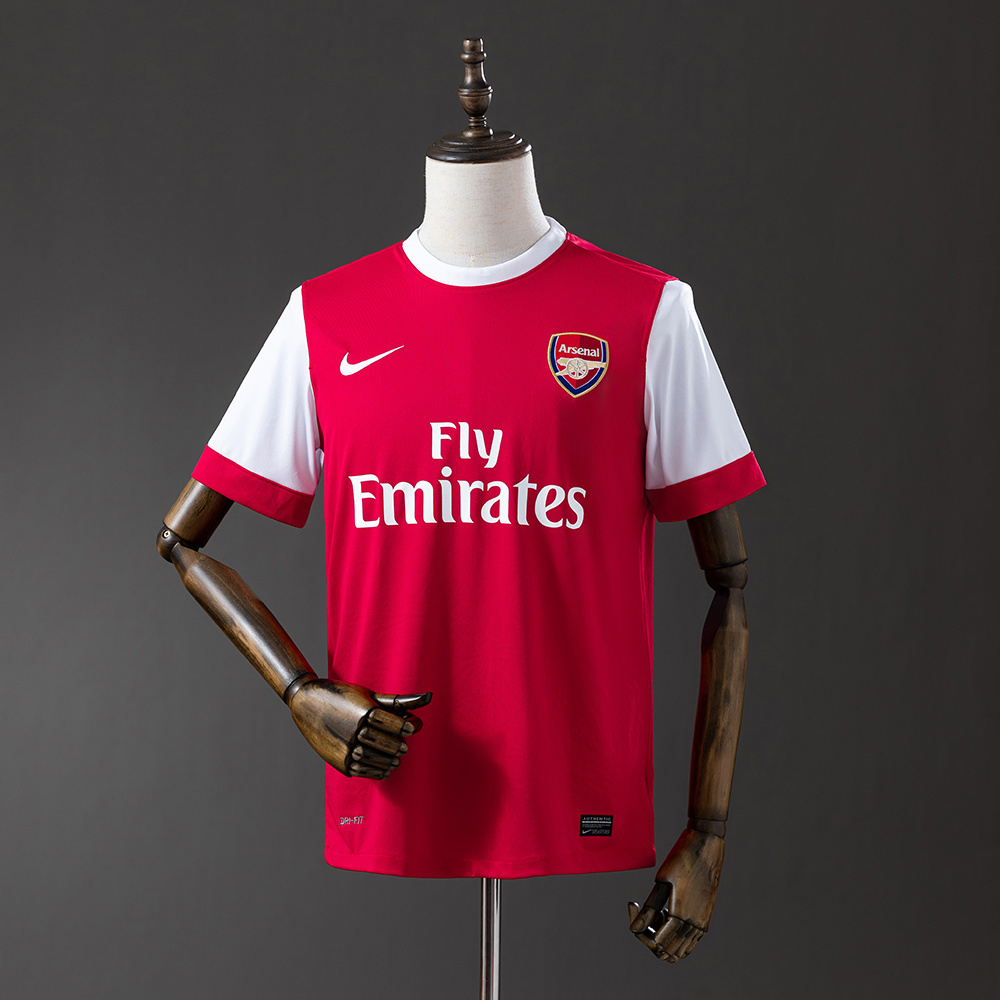 Mens Arsenal Retro Home Jersey 2010/11 Mens Arsenal Retro Home Jersey 2010/11 on hanger showing red body with white raglan sleeves and Fly Emirates sponsor