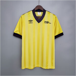 Mens Arsenal Retro Away Jersey 1983/86 on hanger showing canary yellow shadow-stripe body with navy V-neck and cannon badge