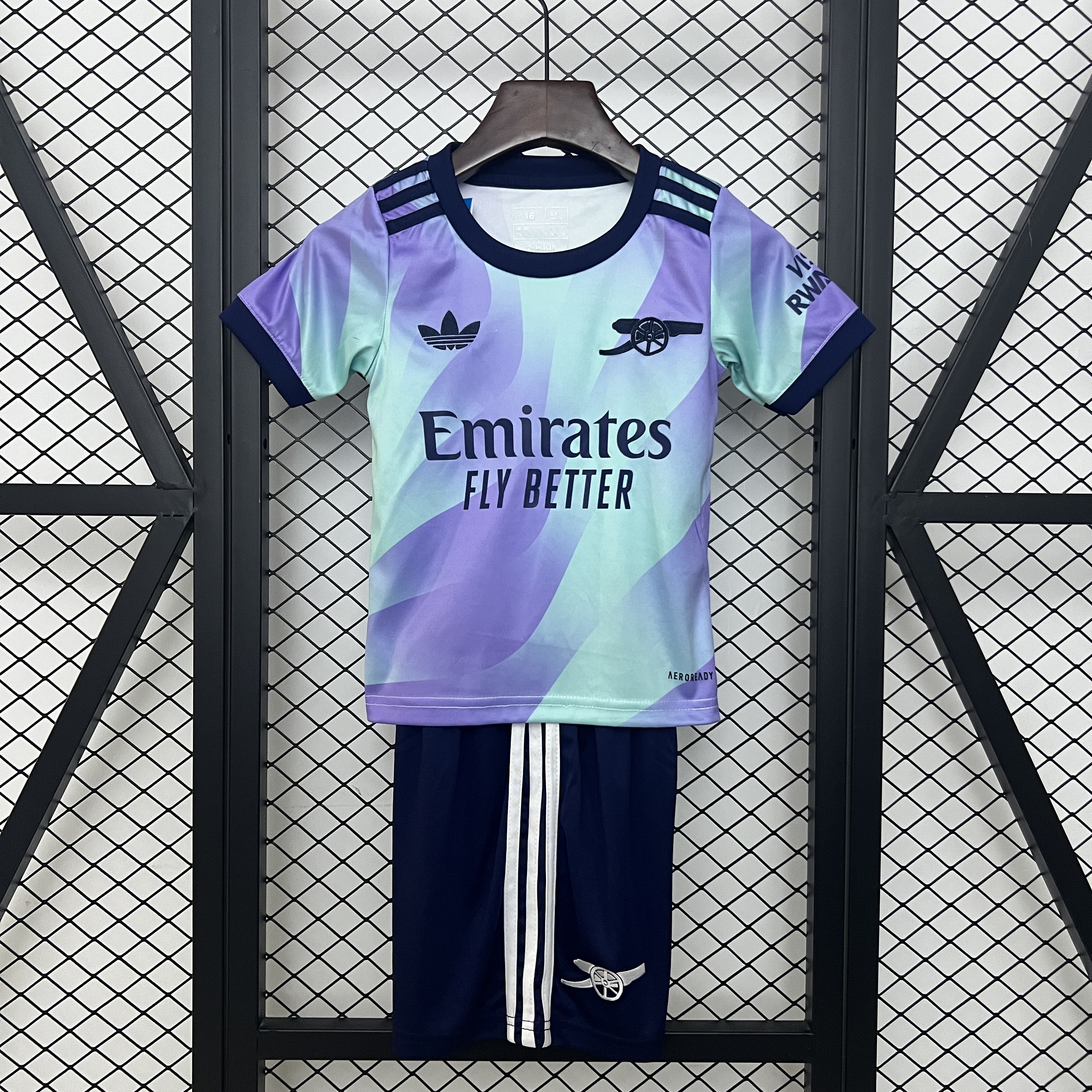 Kids Arsenal Third Kit 2024/25 Kids Arsenal Third Kit 2024/25 on display showing lilac and mint gradient jersey with matching dark navy shorts