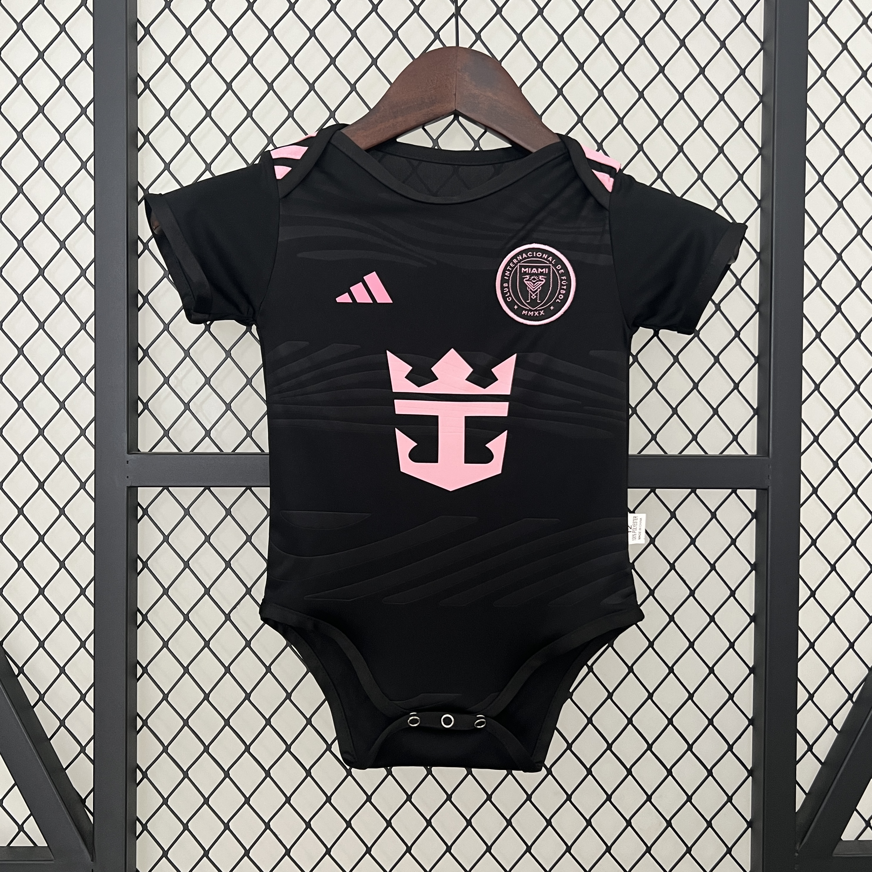 Baby Miami Away Suit 2024/25 Baby Miami Away Suit 2024/25 black infant bodysuit showing pink crest and sponsor