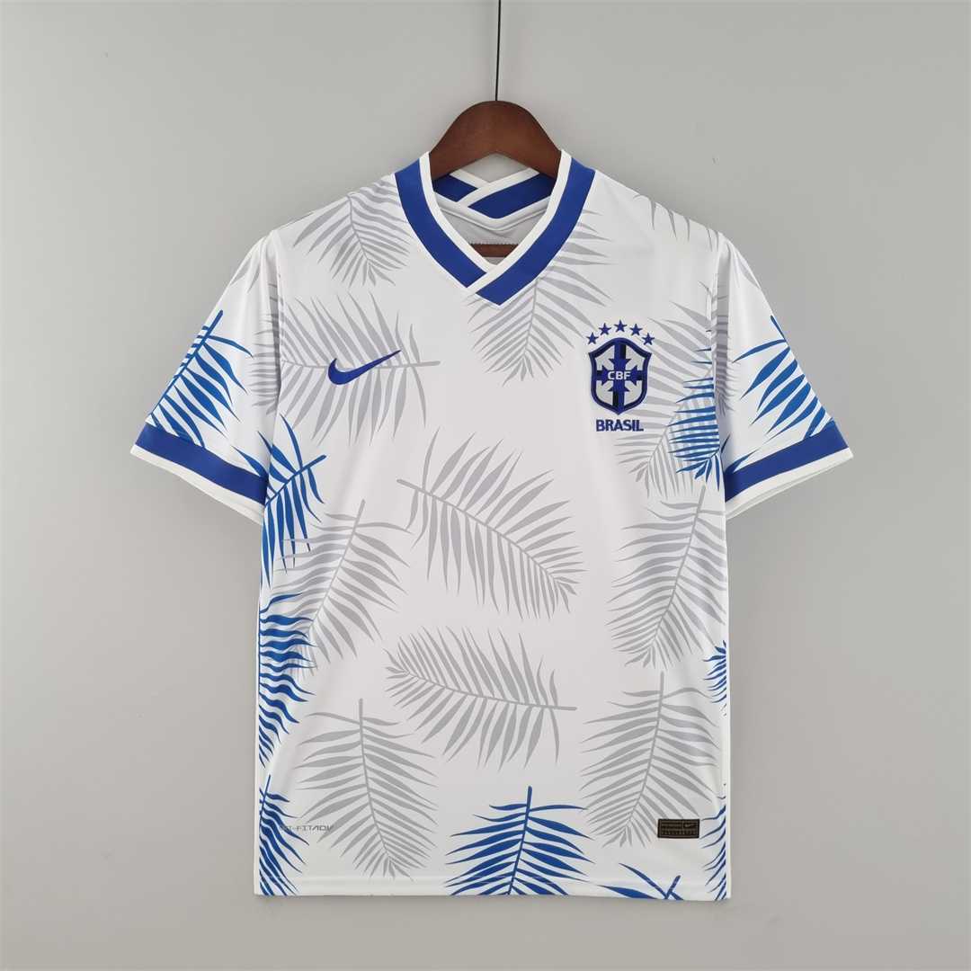 Mens World Cup Brazil classic white Jersey 2022 Mens World Cup Brazil classic white Jersey 2022 on hanger showing white body with blue palm frond prints