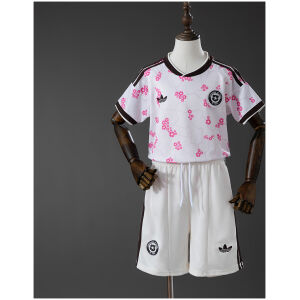 Front view of the Kids Chile Away Kit 2026 showing the white jersey with pink floral graphics and matching white shorts on a mannequin.