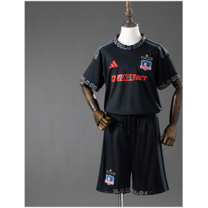 Front view of the Kids Colo Colo Away Kit 2026/27 showing black jersey with red JUGA BET sponsor and matching shorts
