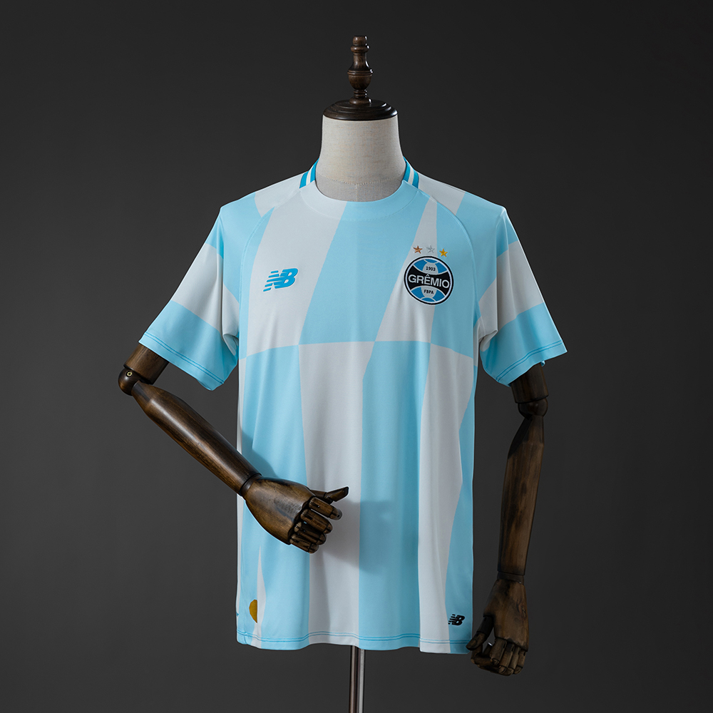 Mens Gremio Away Jersey 2026/27 Mens Gremio Away Jersey 2026/27 front view in sky blue and white with geometric block pattern and crest