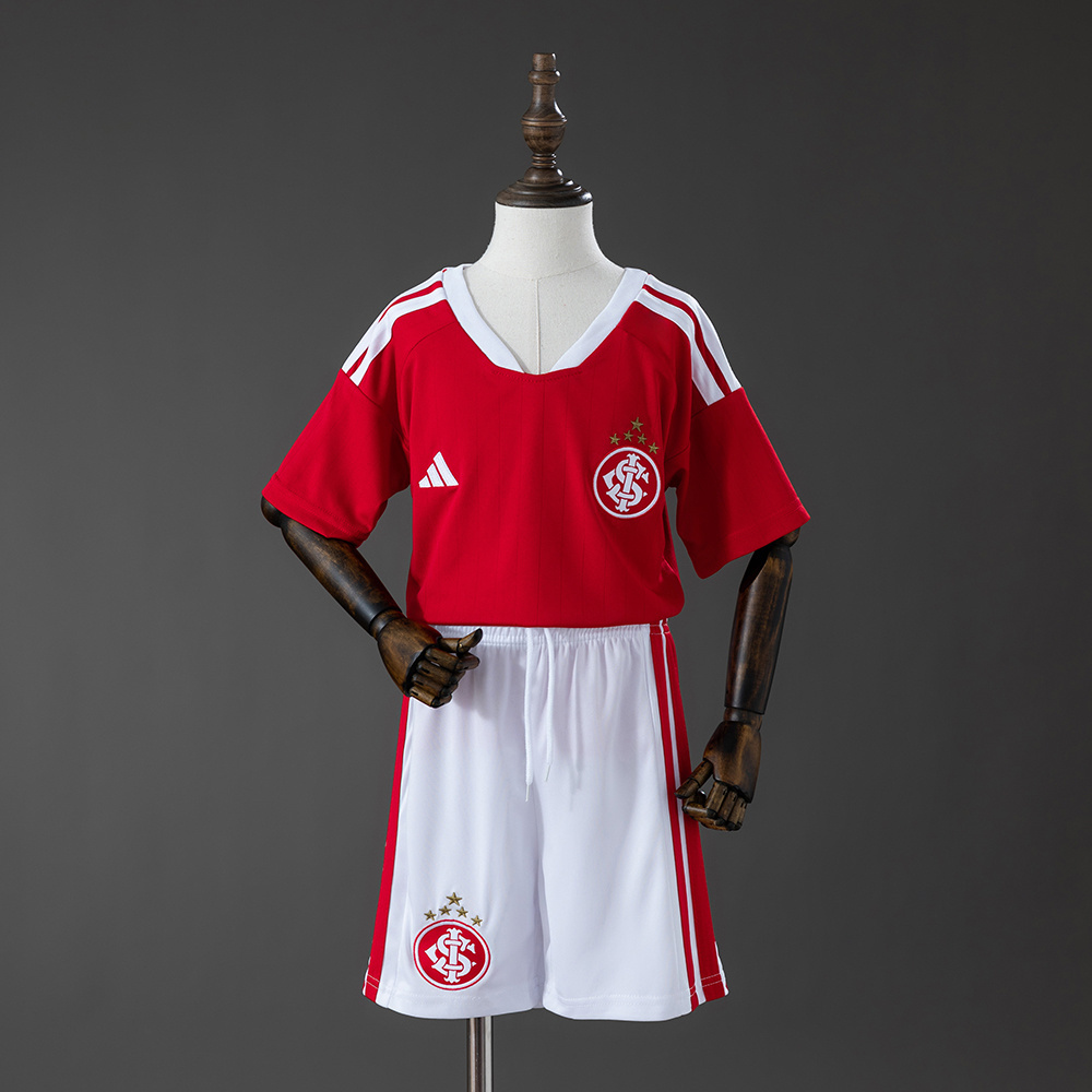 Kids Internacional Home Kit 2026/27 Front view of the Kids Internacional Home Kit 2026/27 including red home shirt and matching white shorts