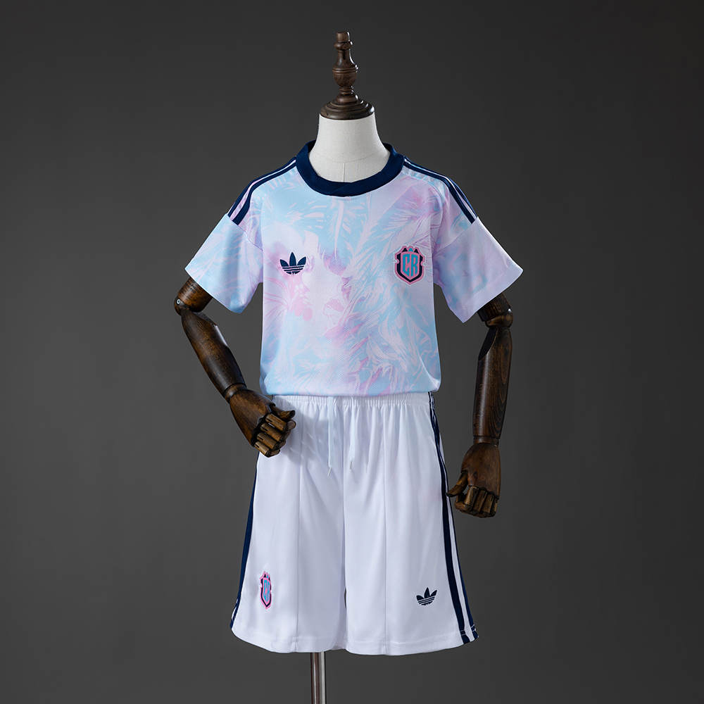 Kids Costa Rica Away Kit 2026 Kids Costa Rica Away Kit 2026 front view showing pastel foliage shirt and matching white shorts with CR crest