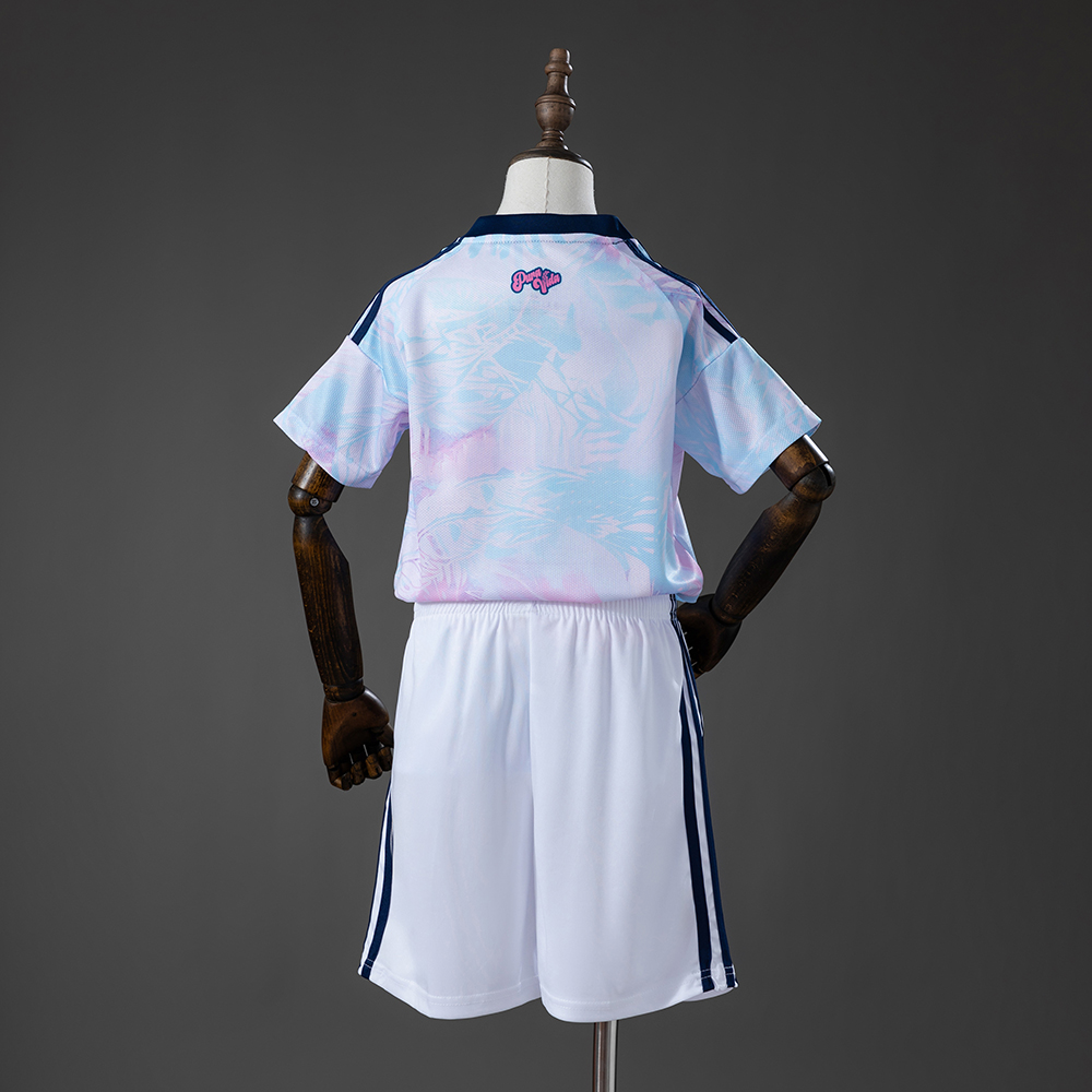 Kids Costa Rica Away Kit 2026 Kids Costa Rica Away Kit 2026 rear view showing pastel patterned jersey with pink Pura Vida script and white shorts