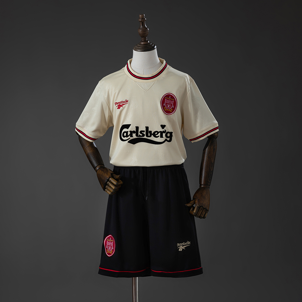 Kids Liverpool Retro Away Kit 1996/97 Kids Liverpool Retro Away Kit 1996/97 front view with ecru jersey, black shorts, and Carlsberg sponsor