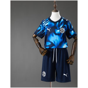 Kids Paraguay Away Kit 2026 Kids Paraguay Away Kit 2026 front view showing blue and cyan smoke graphic jersey with navy shorts