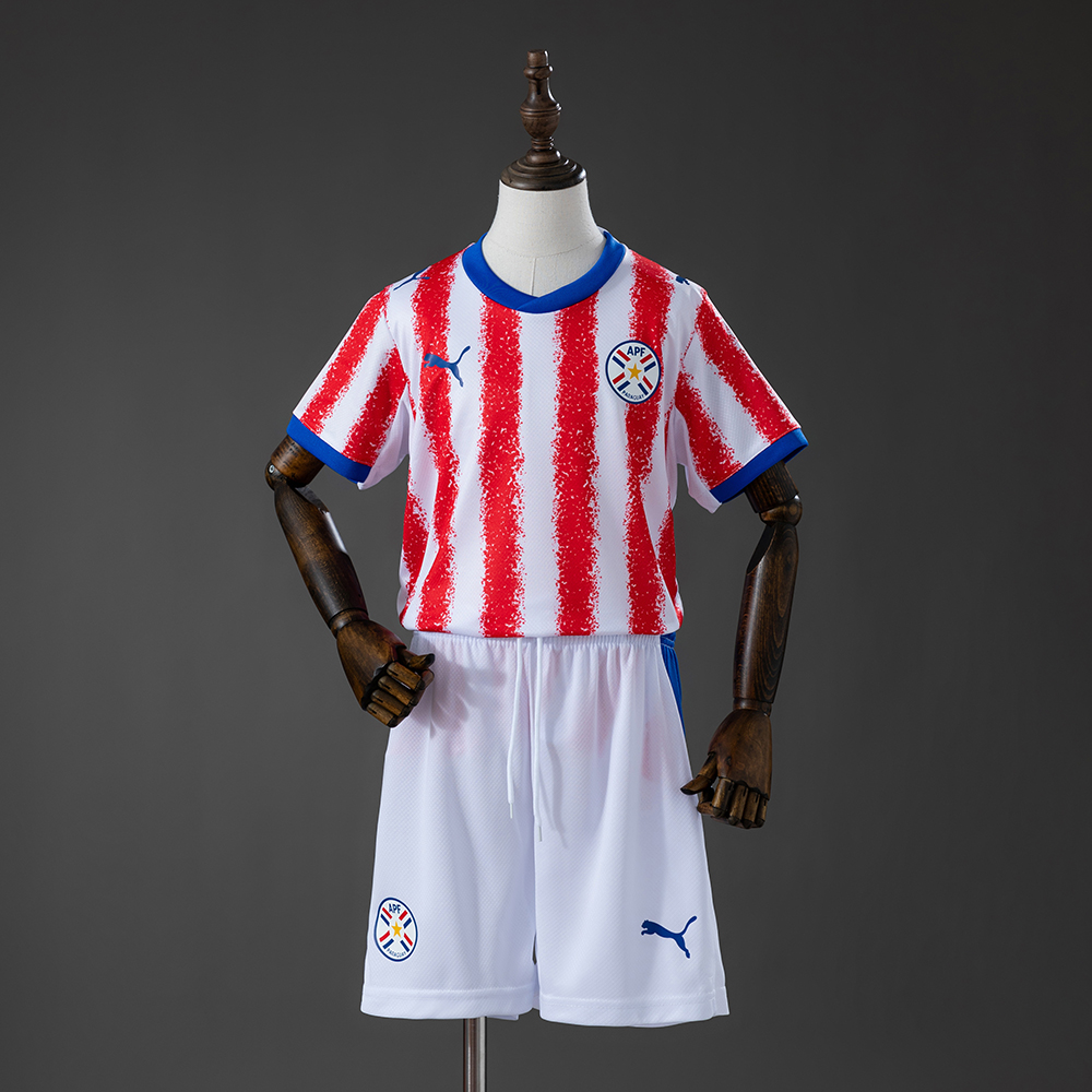 Kids Paraguay Home Kit 2026 Kids Paraguay Home Kit 2026 front view featuring red and white striped jersey with white shorts