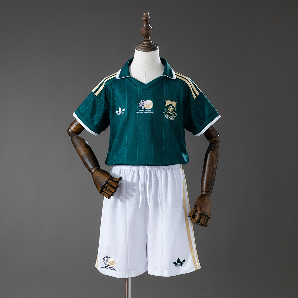 Kids South Africa Away Kit 2026 Kids South Africa Away Kit 2026 front view with emerald green polo jersey and white shorts on mannequin