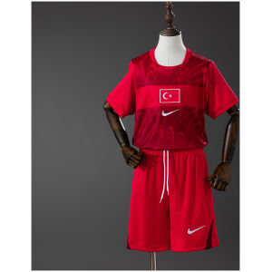 Kids Turkey Away Kit 2026 Front view of the Kids Turkey Away Kit 2026 showing crimson jersey with Ay-Yıldız flag emblem, marble graphics, and matching red shorts on a mannequin.