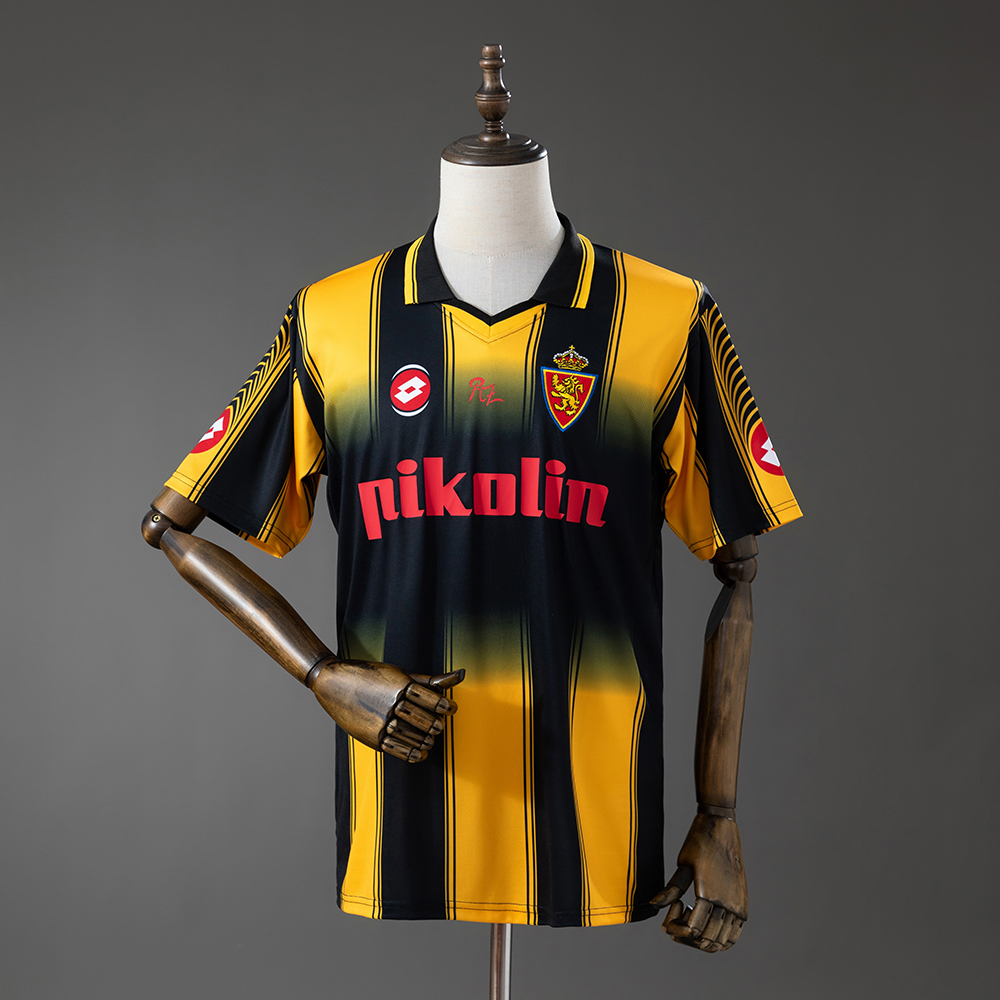 Mens Zaragoza Retro Away Jersey 2003/04 Front view of the Mens Zaragoza Retro Away Jersey 2003/04 displaying black and yellow stripes, Pikolin sponsor, and Real Zaragoza crest on a mannequin.