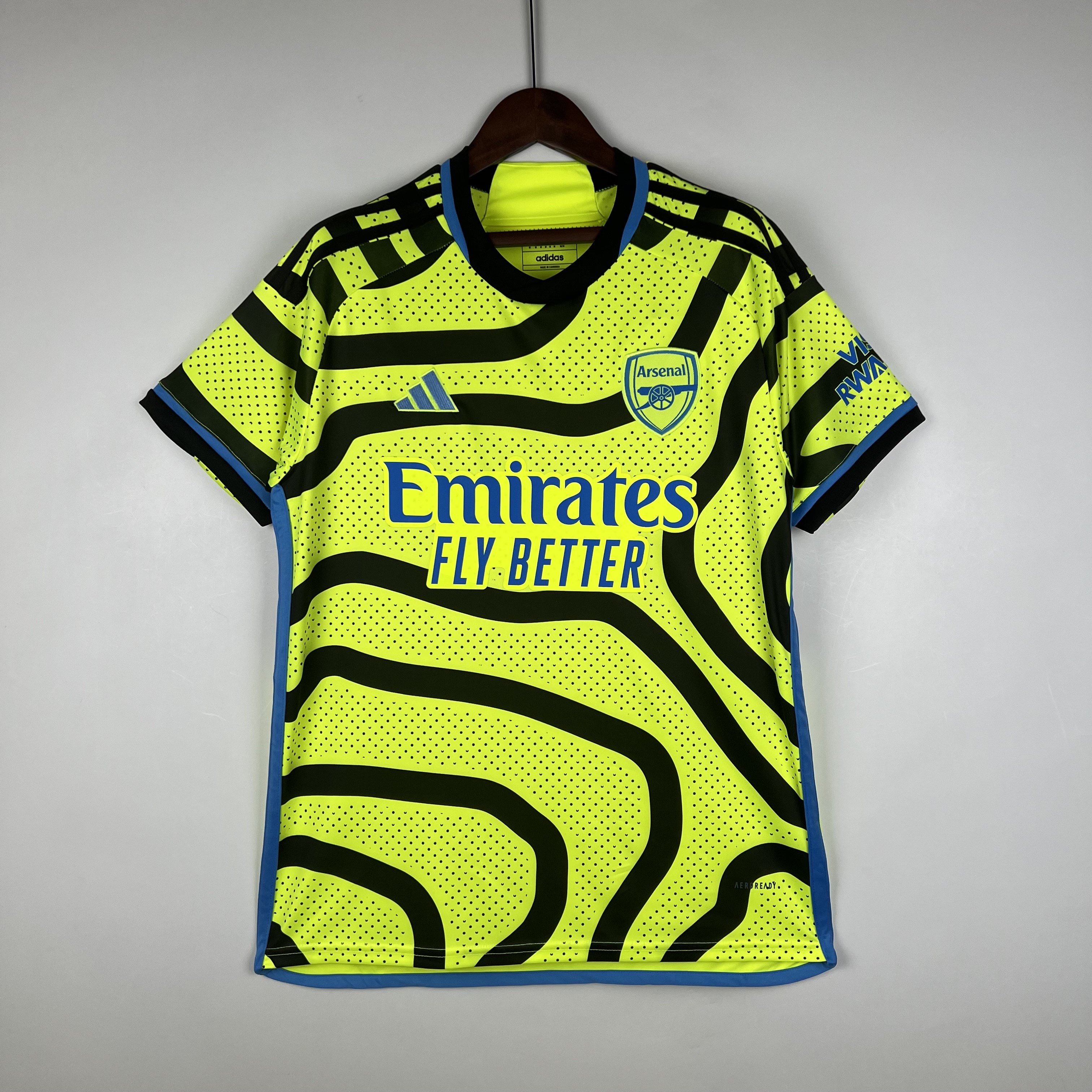 Mens Arsenal Away Jersey 2023/24 Mens Arsenal Away Jersey 2023/24 on hanger showing shock yellow body with black topographic map lines and blue trim