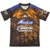 Mens Club America Third Jersey 2026/27 black shirt front view with golden amber eagle graphic and blue shoulder stripes