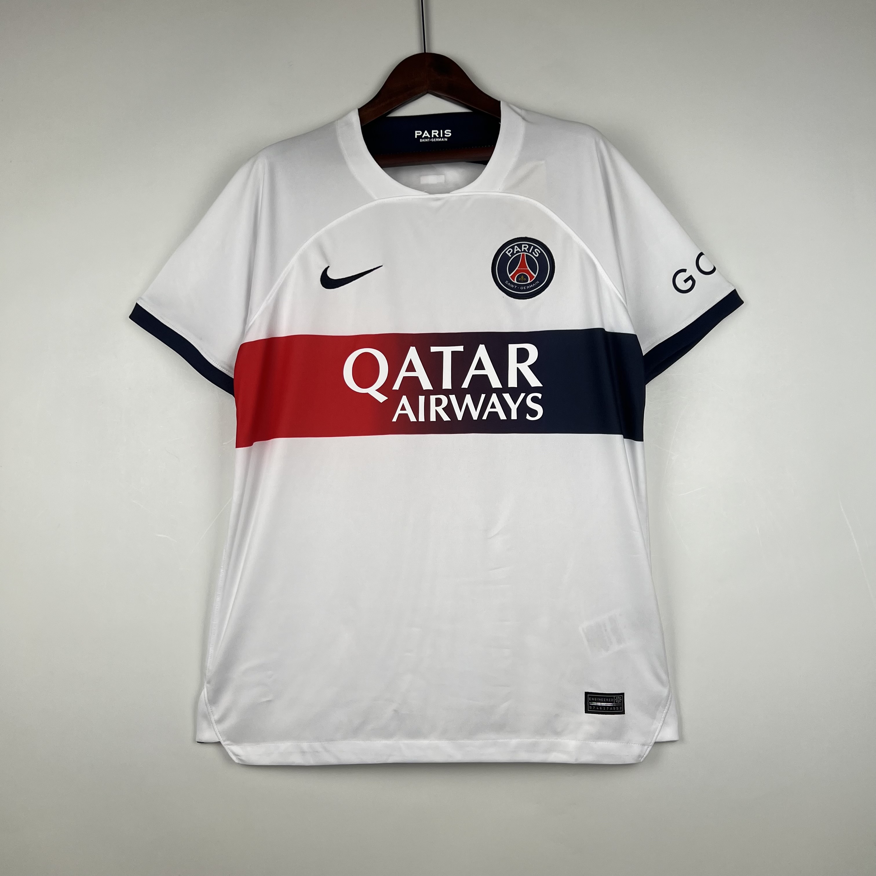 Mens PSG Away Jersey 2023/24 Mens PSG Away Jersey 2023/24 on hanger showing crisp white torso with red-to-navy gradient chest band