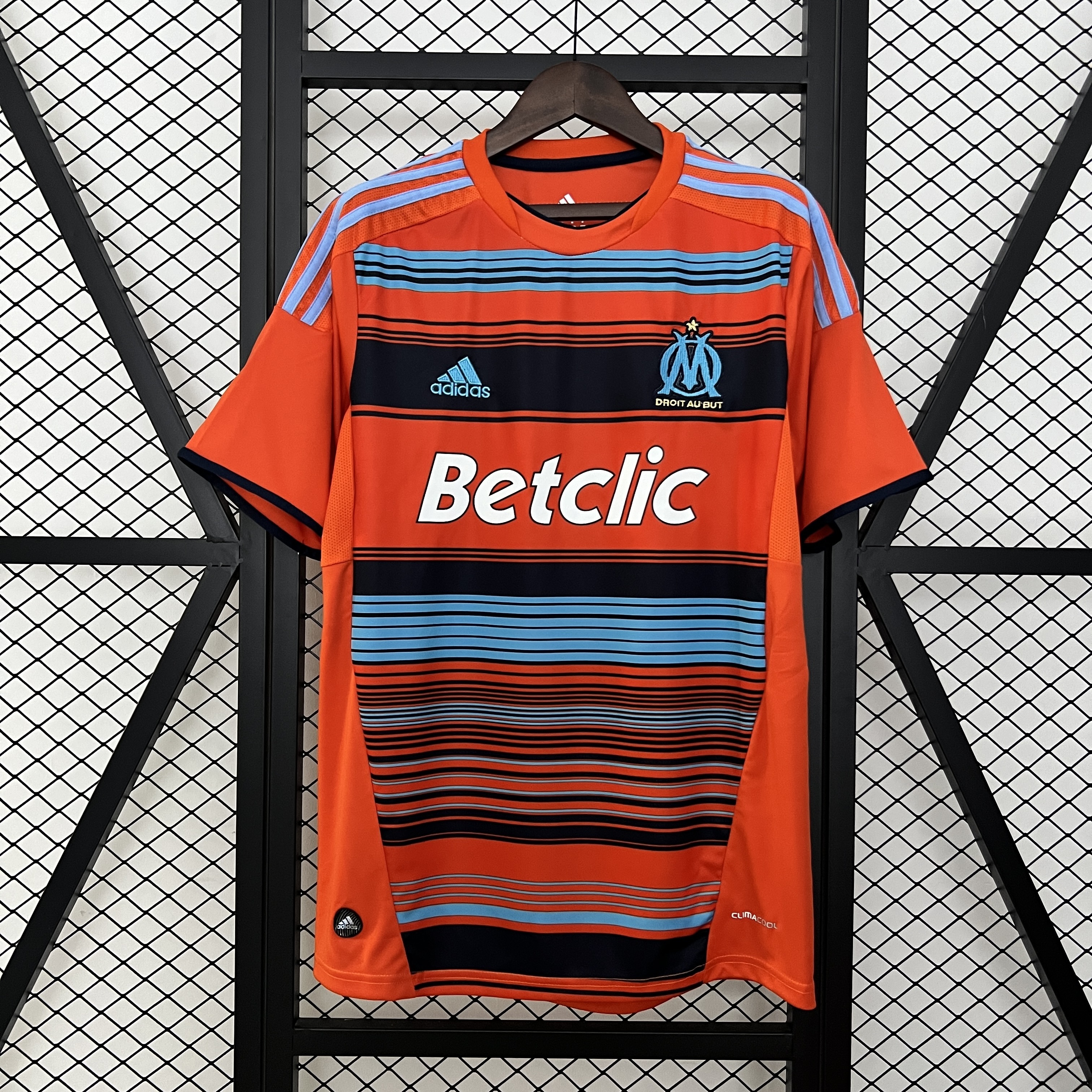 Mens Marseille Retro Third Jersey 2011/12 Mens Marseille Retro Third Jersey 2011/12 on hanger showing bright orange body and navy-blue horizontal stripes