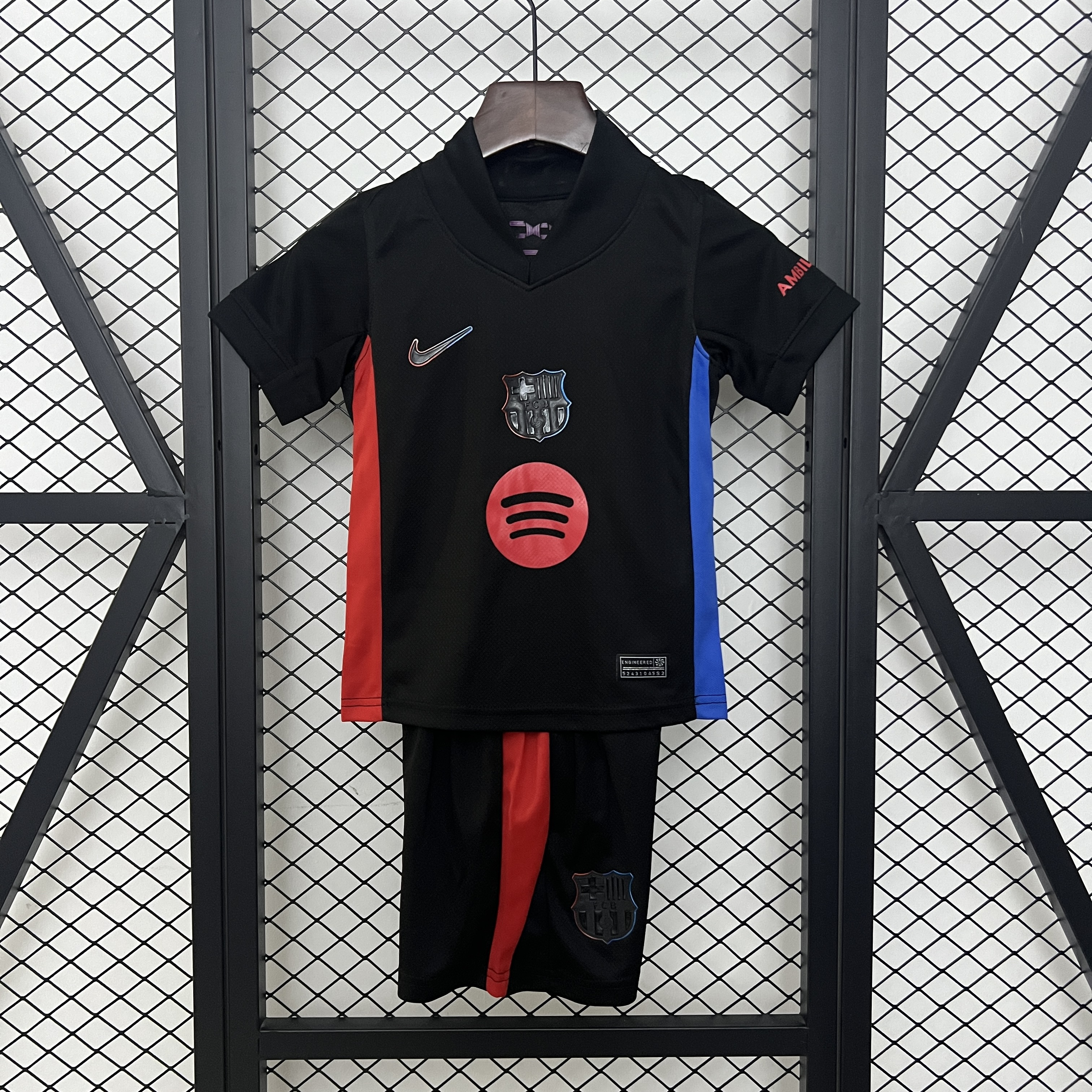 Kids Barcelona Away Kit 2024/25 Kids Barcelona away kit black shirt with red and blue side panels front view