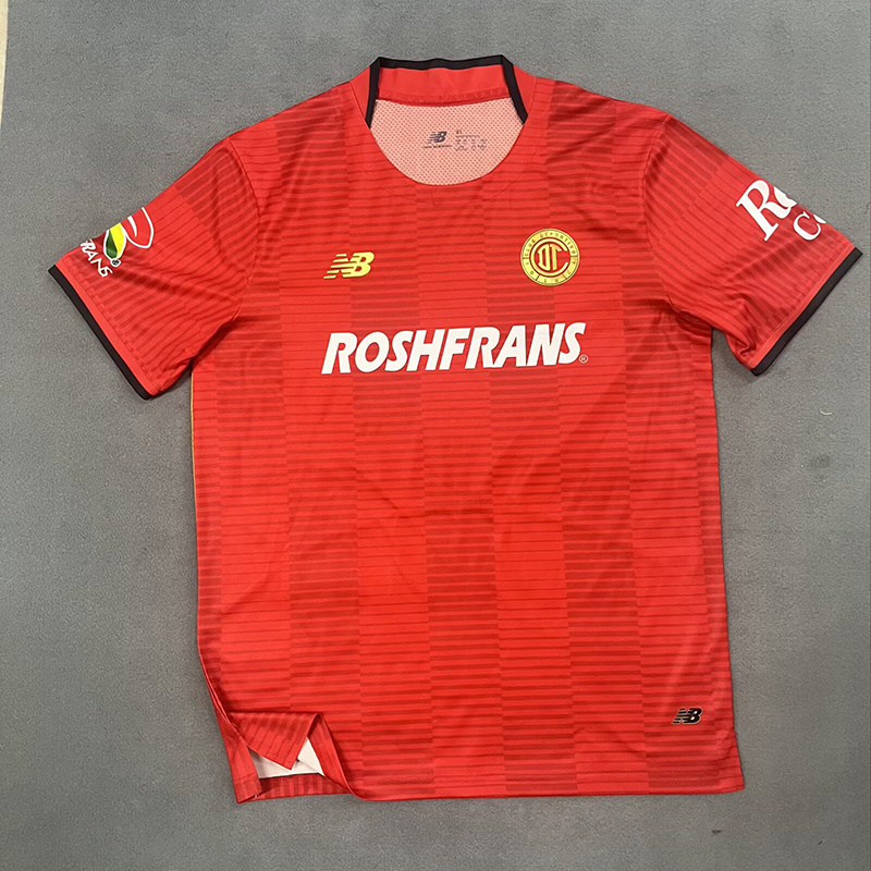 Mens Toluca Home Jersey 2025/26 Mens Toluca Home Jersey 2025/26 front view in scarlet red with tonal stripes and Roshfrans sponsor