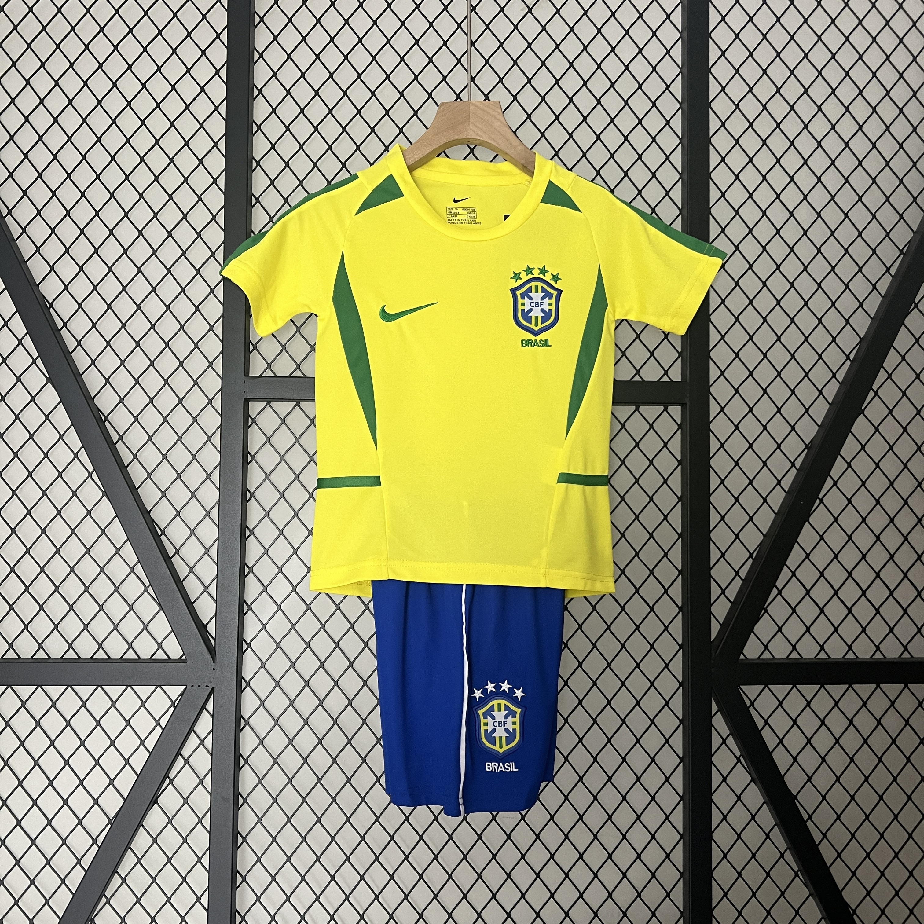 Kids World Cup Brazil Retro Home Kit 2002 Front view of the Kids World Cup Brazil Retro Home Kit 2002 featuring yellow jersey and royal blue shorts