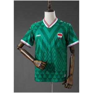 Mens Iraq Away Jersey 2026 front view in green with Mesopotamian pattern and tricolor trim
